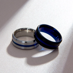 Macro shot of 8mm men's brushed silver and matte black steel rings with blue racing stripes