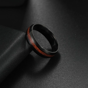 Detail of matte black titanium steel ring featuring natural wood inlay for men
