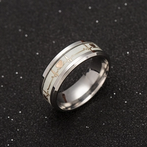 Anello luminoso in acciaio inossidabile con battito cardiaco dorato su fondo nero stellato