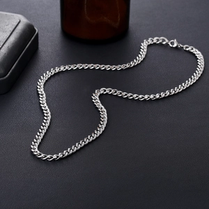 Mens stainless steel silver cuban link chain necklace with lobster clasp on dark stone background