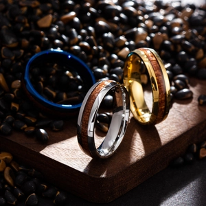 Detailed view of titanium steel rings with wood inlay in blue, gold and silver