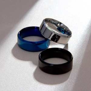 Primer plano de anillos de acero inoxidable en plata, azul y negro con bordes biselados