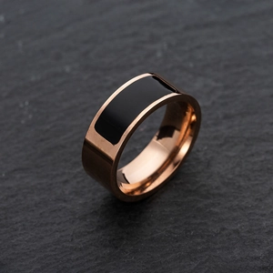 Macro shot of rose gold titanium NFC smart ring with black inlay on grey rock texture