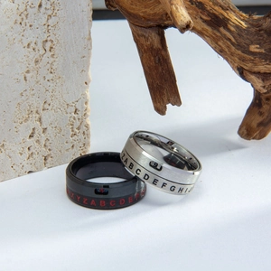 Detail view of rotating titanium steel rings with engraved letters and numbers