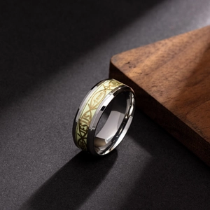 Gros plan d'une bague en acier poli avec poisson Jésus lumineux sur support en bois