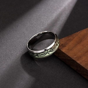 Gros plan détaillé des gravures religieuses de Jésus sur une bague lumineuse en acier