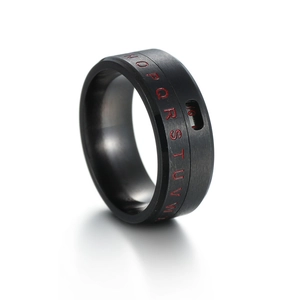 Macro detail of black rotatable titanium ring with red engraved letters and numbers