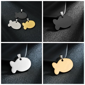 Dettaglio macro di ciondoli a forma di pesce in acciaio inossidabile oro, argento e nero