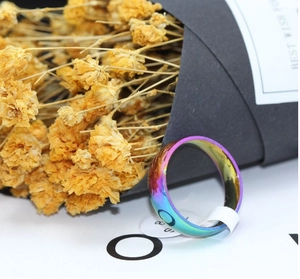 Detail of a rainbow gradient stainless steel ring with a smooth polished curved finish