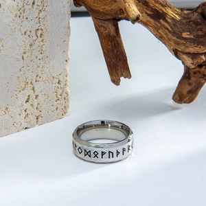 Close-up of Viking runes engraved on a hammered silver stainless steel ring surface
