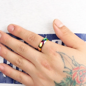 Macro detail of rainbow gradient titanium steel ring showing smooth curved colorful surface