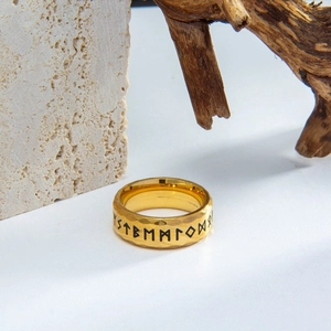 Detailed macro shot of vintage gold Norse Viking rune ring with hammered metal texture