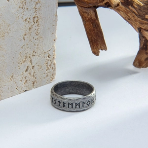 Macro view of vintage titanium steel Viking rune ring on a rustic natural stone base