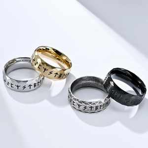 Detail of four stainless steel Nordic rune rings in gold, silver, black, and vintage finishes