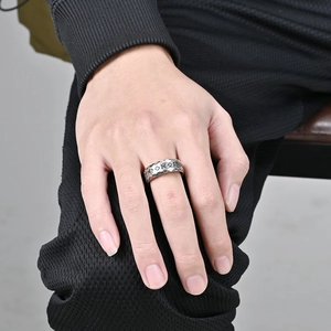 Detail of vintage silver titanium ring featuring Nordic runes and geometric carved edges