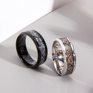 Close-up of black and silver rings featuring intricate Celtic dragon patterns and polished finish