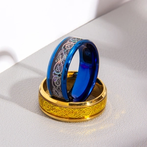 Macro shot of Celtic dragon patterns on blue and gold wide bands for men
