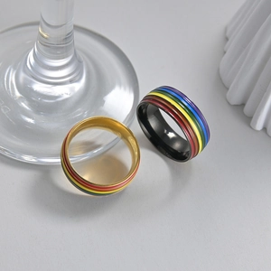 Macro view of rainbow enamel stripes on gold and black stainless steel rings