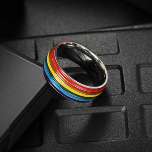 Close-up of rainbow striped titanium steel ring with vibrant enamel inlay and polished finish