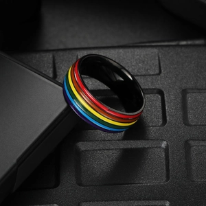 Macro shot of black titanium ring featuring vibrant rainbow enamel stripes detail