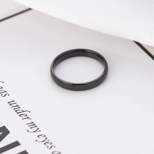 Close-up of minimalist black titanium ring with a sleek semi-matte finish and narrow band