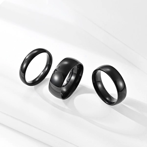 Three black polished titanium steel rings in different widths on a white background