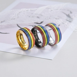 Titanium steel rainbow pride rings in gold, black, and silver finishes with enamel stripes