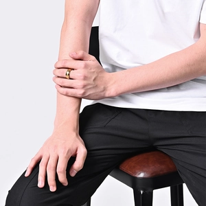 Polished gold titanium ring shown on a finger featuring a minimalist wide surface design