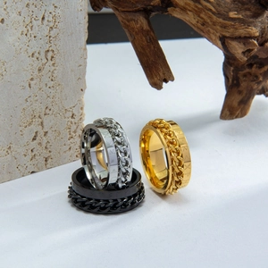 Detalle de anillos giratorios Vikingo en oro, plata y negro con runas y cadena central