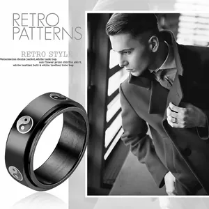 Macro view of rotating black stainless steel ring with Yin Yang pattern and matte finish
