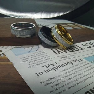 Detailed view of three vintage steel rings with meteorite texture and serrated edges