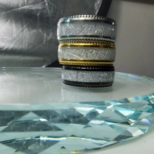 Macro detail of men's wide rings with meteorite pattern and non-slip gear edges