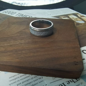 Detail view of retro embossed stainless steel ring with meteorite texture and gear edges