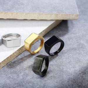 Dettaglio di quattro anelli a sigillo rettangolari in argento, oro, nero e grigio