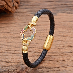 Detail van zwarte gevlochten leren armband met gekleurde zirkoon op gouden magneetsluiting