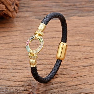 Macro-opname van zwart gevlochten leren armband met goudkleurige gesp met zirkonia