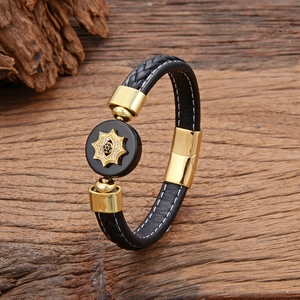 Men's hand-woven leather bracelet with gold star ornament and magnetic clasp on wood