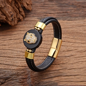 Détail du bracelet en cuir tressé montrant la tête de léopard dorée avec zircons blancs