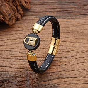 Close-up of black braided leather bracelet with golden lock charm and crystal inlay