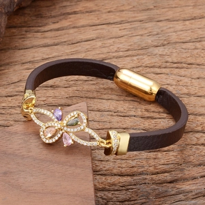 Brown braided leather bracelet with golden butterfly charm and multi-colored gemstones