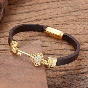 Braided leather bracelet with golden heart-shaped key pendant and magnetic clasp