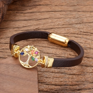 Detailed macro view of tree of life charm on brown leather strap with magnetic clasp