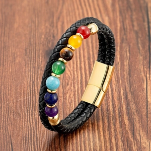 Détail d'un bracelet chakra en cuir tressé avec sept perles colorées et fermoir magnétique doré