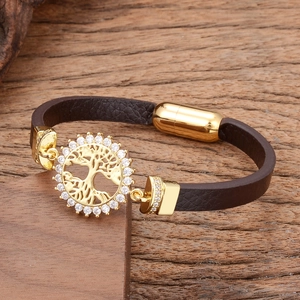 Detail of leather bracelet with golden tree of life charm and clear zircon stones