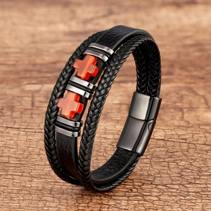 Dettaglio del bracciale in pelle fatto a mano con croce arancione e chiusura magnetica