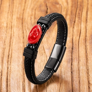 Close-up of black braided leather bracelet with red cinnabar charm and magnetic clasp