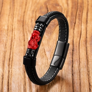 Detail of black woven leather bracelet with red Pixiu charm and magnetic clasp