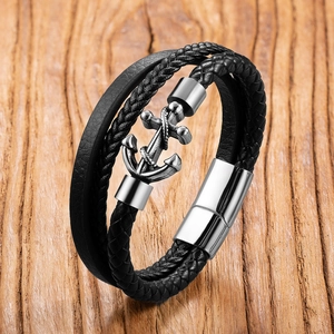 Detailansicht eines mehrlagigen Lederarmbands mit Silberanker auf Holzhintergrund