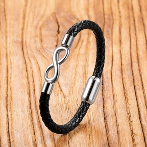 Detail view of black braided leather bracelet with silver infinity charm and magnetic clasp