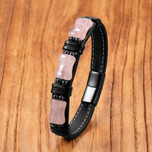 Men's leather bracelet with pink natural stones and magnetic clasp on wooden background